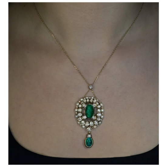 Necklace with emerald and diamond pendant on a person's neck