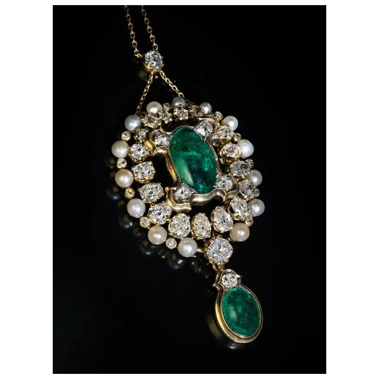 Ornate necklace with emerald and pearl pendant on a black background