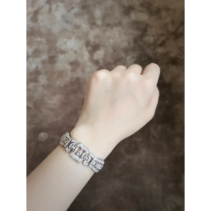 Silver bracelet on a wrist against a textured brown background