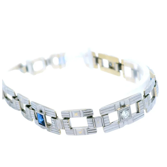 Silver bracelet with blue gemstone and clear stone on a white background