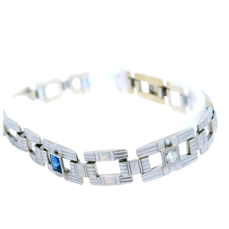 Silver bracelet with blue gemstone and clear stone on a white background