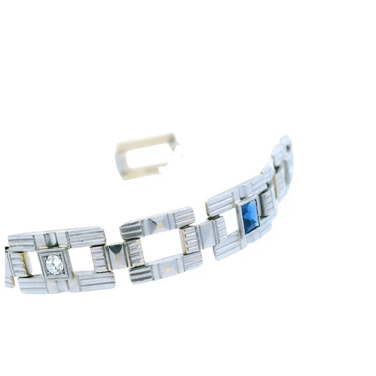 Silver bracelet with blue gemstone and clear stone on a white background