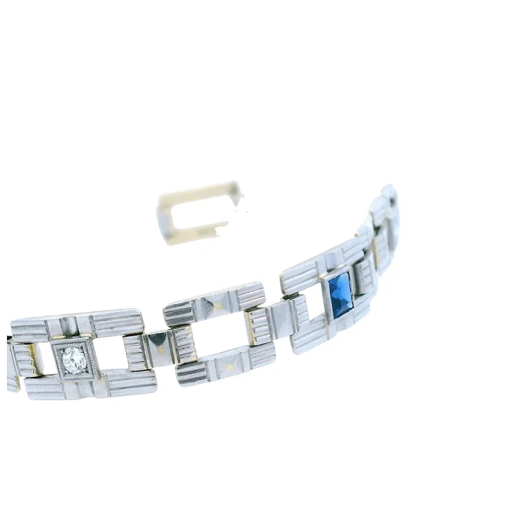 Silver bracelet with blue gemstone and clear stone on a white background