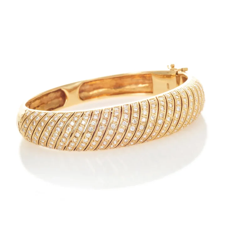 Gold bracelet with diamond accents on a white background