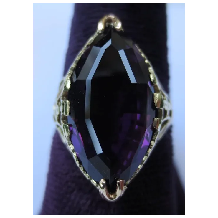 Ring with a large purple gemstone on a dark background