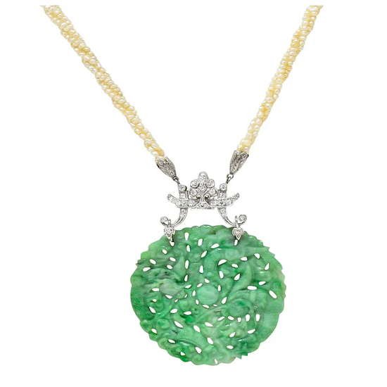 Green jade pendant with silver star design on a gold chain against a white background