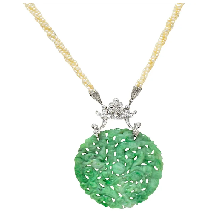 Green jade pendant with silver star design on a gold chain against a white background