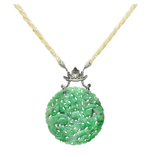 Green jade pendant on a gold chain against a white background