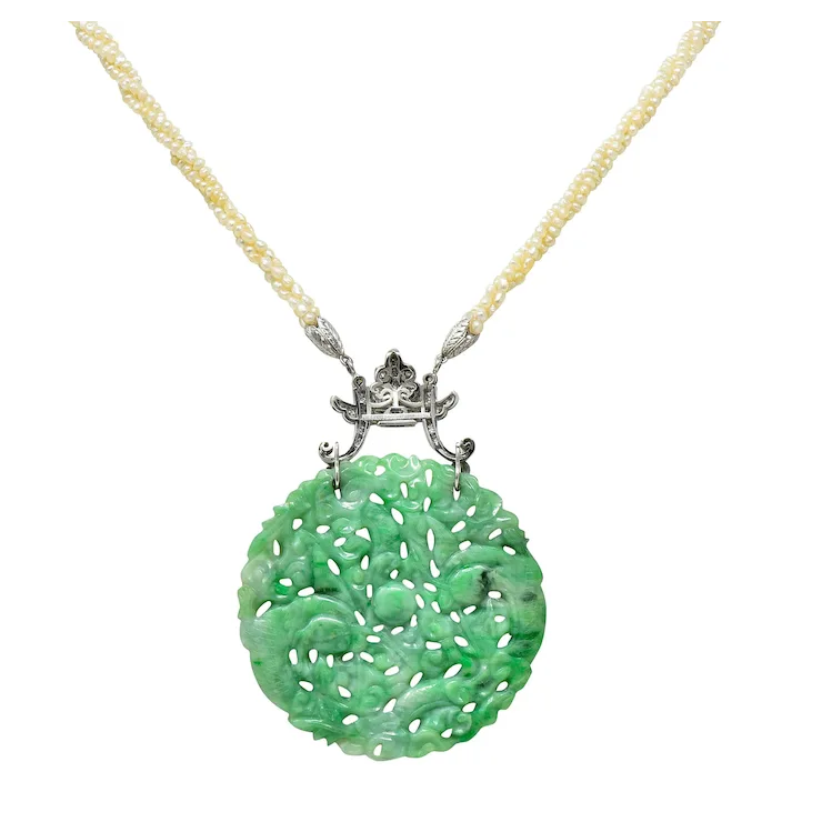 Green jade pendant on a gold chain against a white background