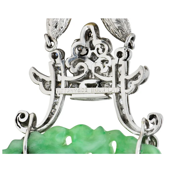 Close-up of a silver necklace with green pendant on a white background