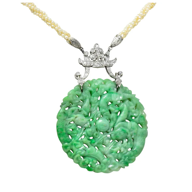 Green jade pendant with silver and diamond accents on a white background