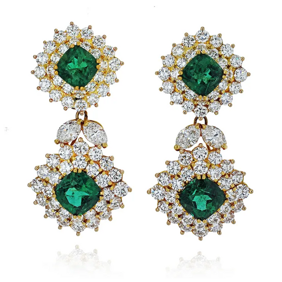 Pair of earrings with green gemstones and gold accents on a white background