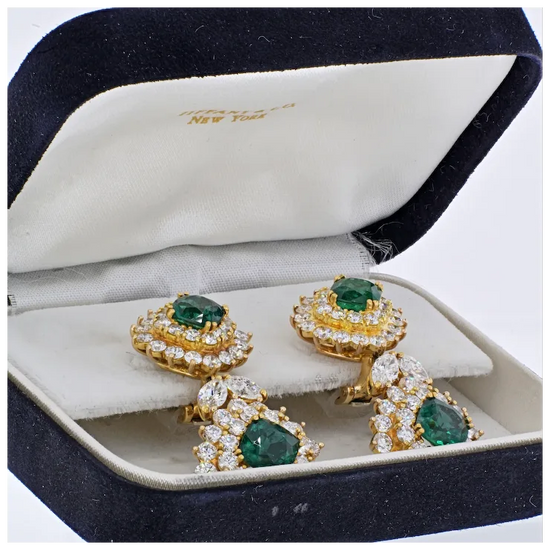 Gold earrings with emeralds and diamonds in a jewelry box
