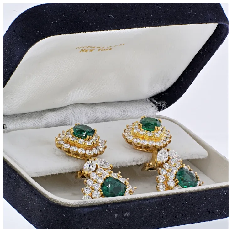 Gold earrings with emeralds and diamonds in a jewelry box
