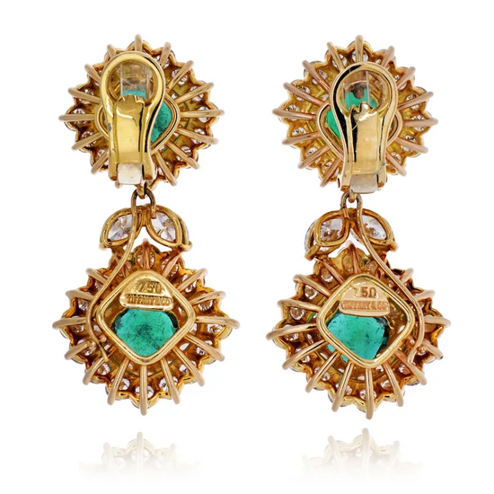 Gold earrings with green gemstones on a white background