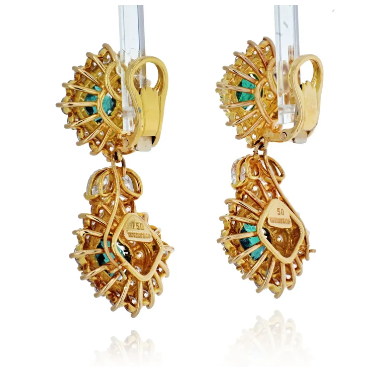 Gold earrings with intricate design and turquoise stones on a white background