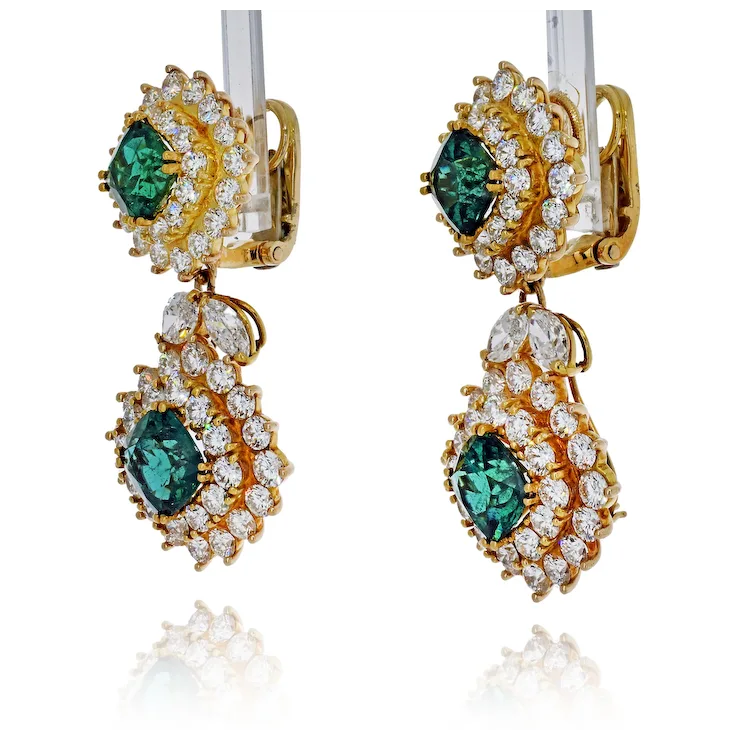Gold earrings with green gemstones and clear stones on a white background