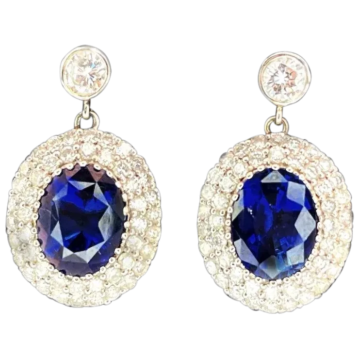 Pair of earrings with blue gemstones and gold accents on a white background