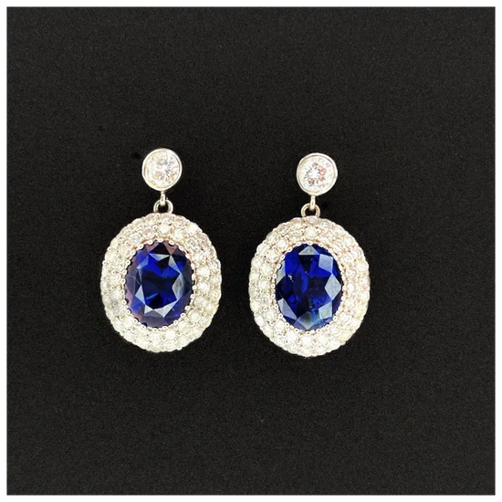 Pair of earrings with blue gemstones and gold accents on a black background