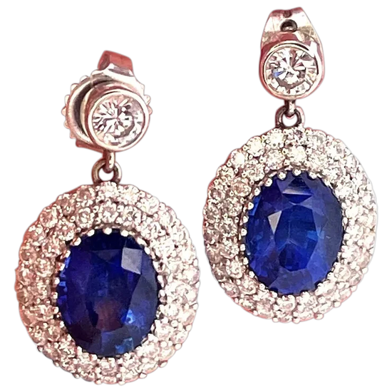 Pair of earrings with blue gemstones and rose gold accents on a white background