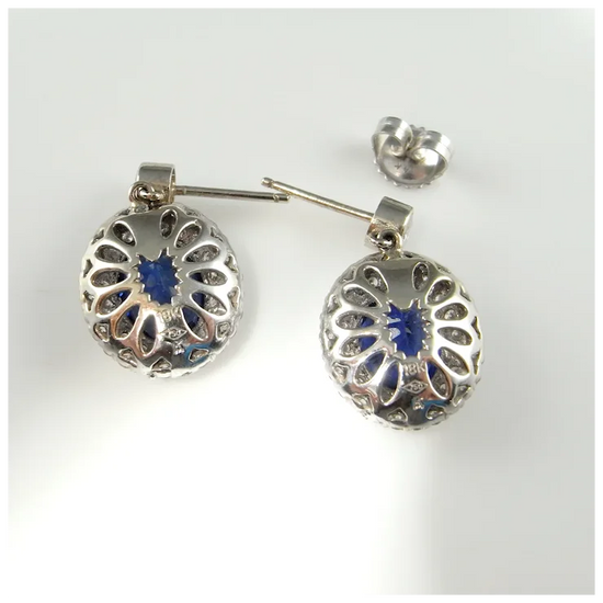 Silver earrings with blue gemstones on a white background