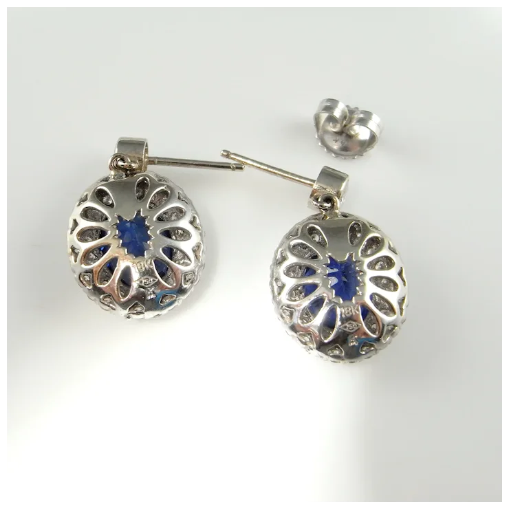 Silver earrings with blue gemstones on a white background
