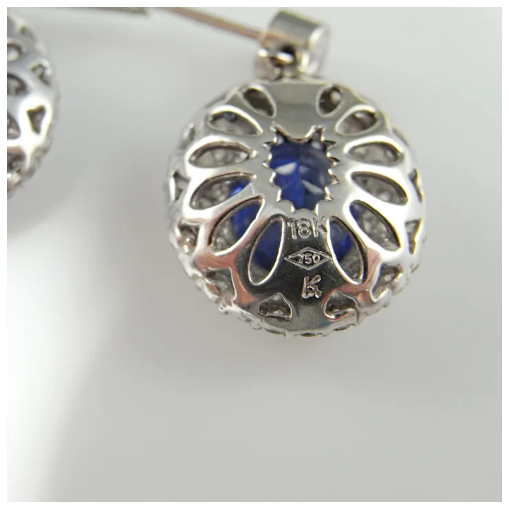 Silver pendant with blue center and '18K' marking on a white background