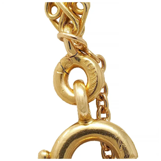 Close-up of a gold chain with intricate design on a white background