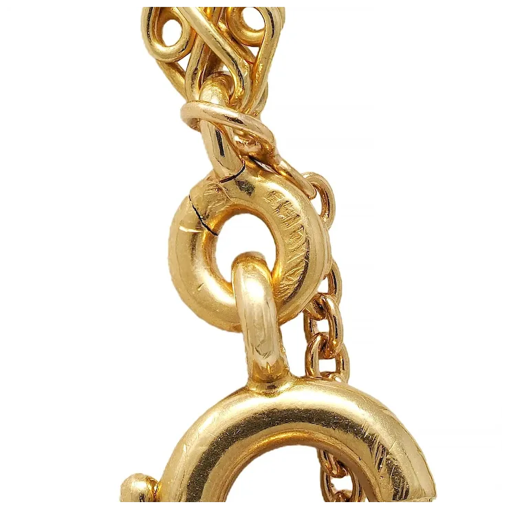 Close-up of a gold chain with intricate design on a white background