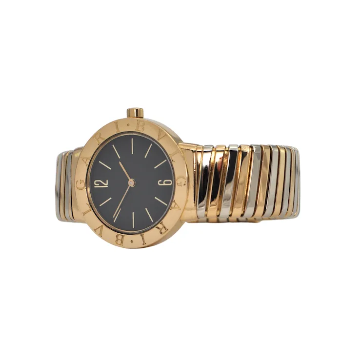 Gold and silver watch with black face on a white background