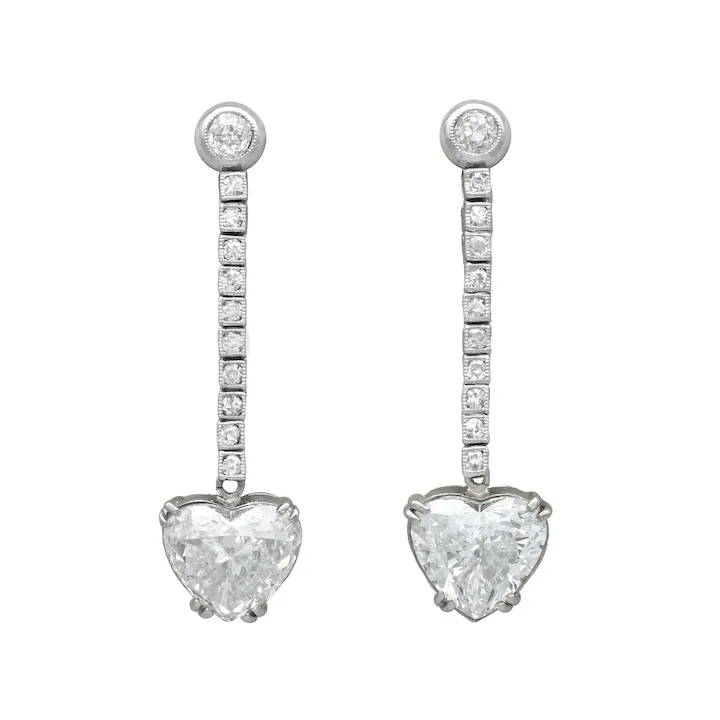 Heart-shaped diamond earrings on a white background