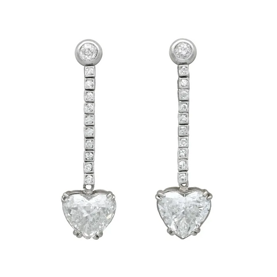 Heart-shaped diamond earrings on a white background