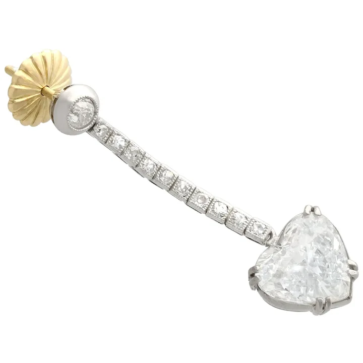 Diamond earring with heart-shaped diamond and gold accent on a white background