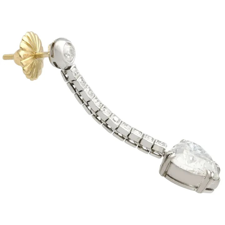 Diamond earring with a gold and silver setting on a white background