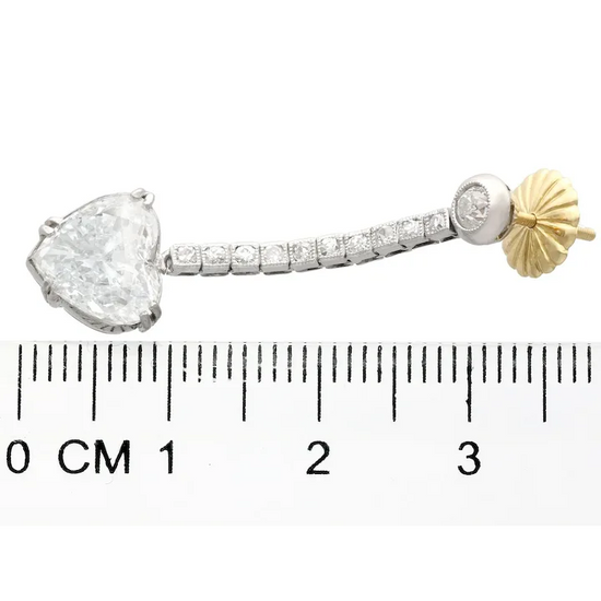 Jewelry piece with a heart-shaped gemstone and gold accent, shown with a ruler for scale.
