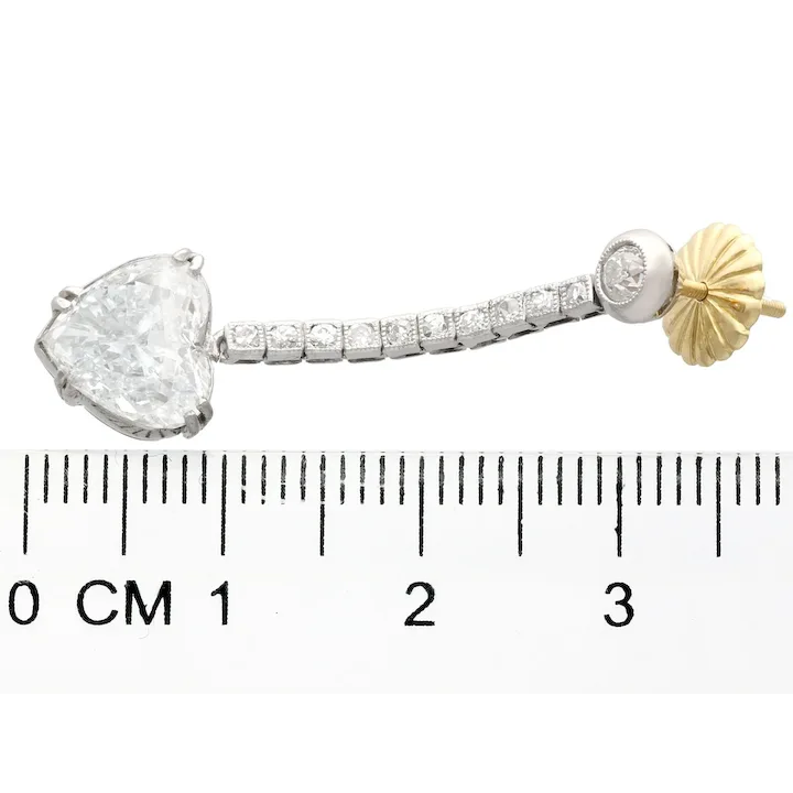 Jewelry piece with a heart-shaped gemstone and gold accent, shown with a ruler for scale.