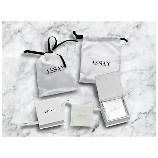 Assay jewelry packaging on a marble surface