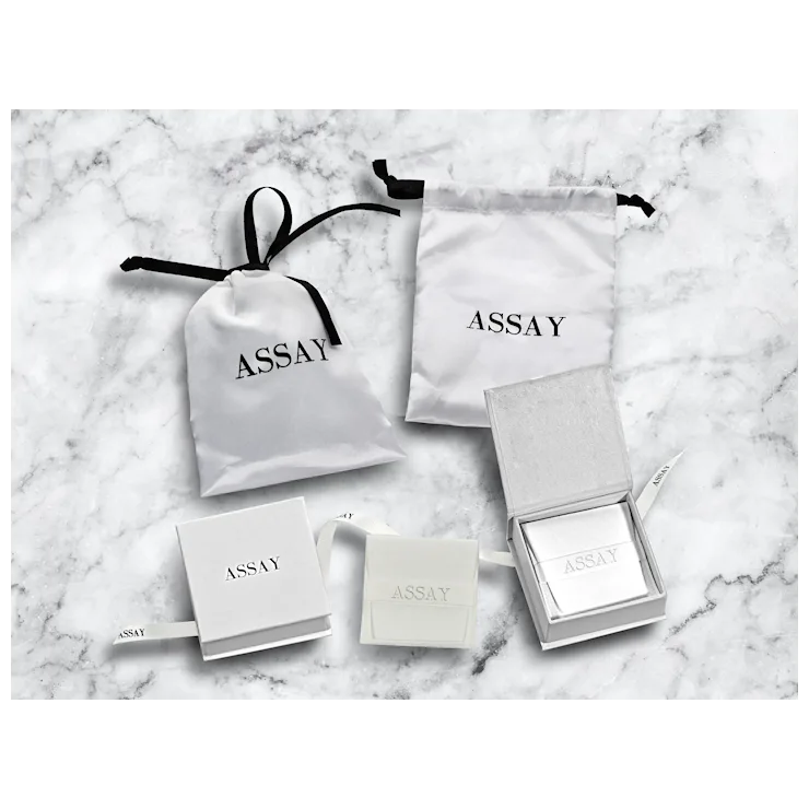 Assay jewelry packaging on a marble surface