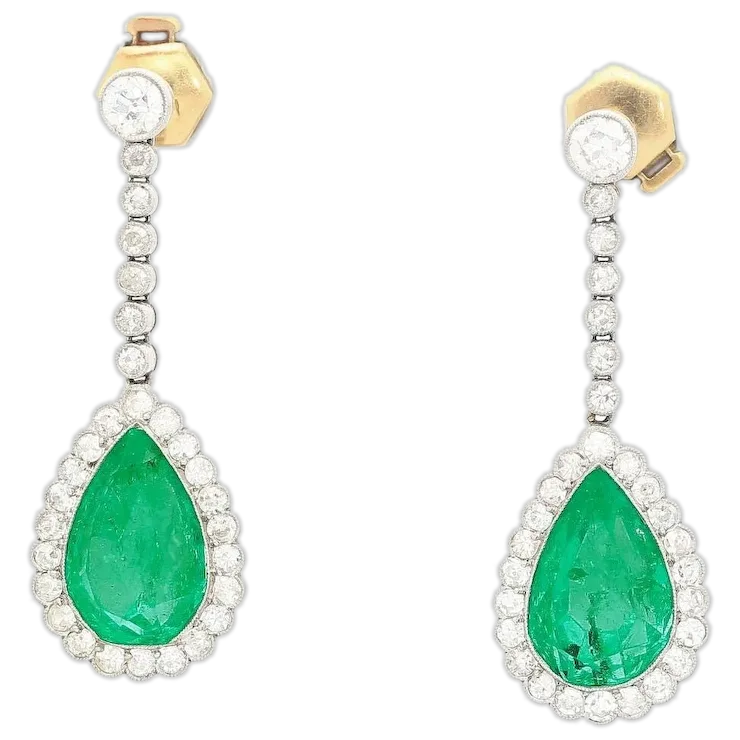 Pair of emerald and diamond earrings on a white background