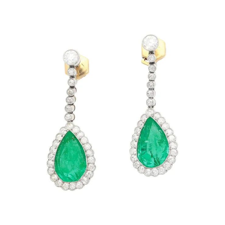 Pair of emerald and diamond earrings on a white background