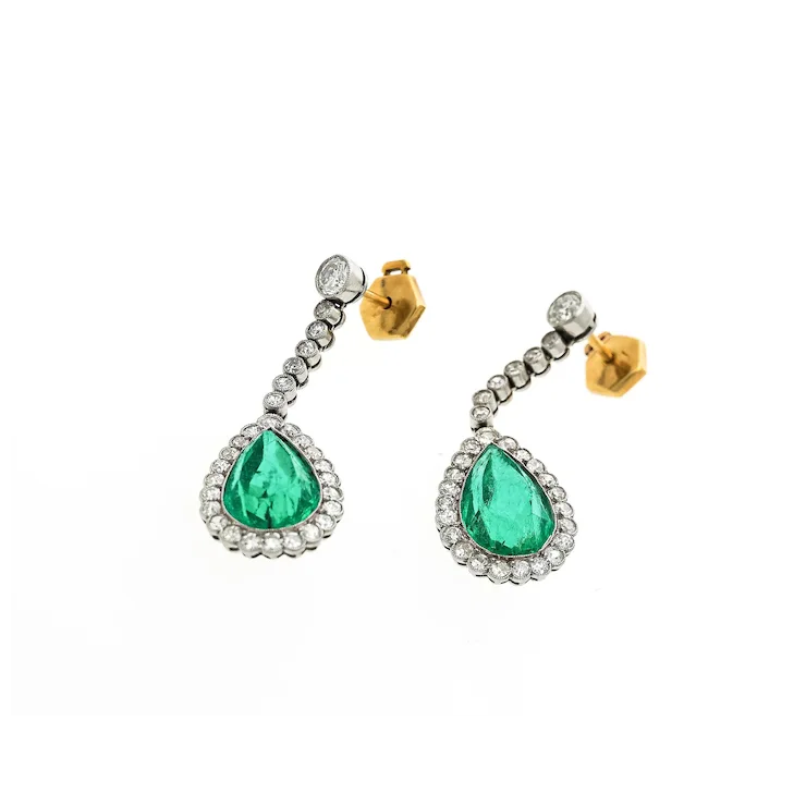 Pair of earrings with green teardrop stones on a white background