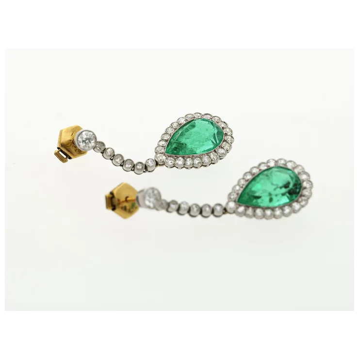 Pair of earrings with green gemstones and gold accents on a white background