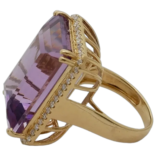 Gold ring with a large purple gemstone and smaller diamonds on a white background