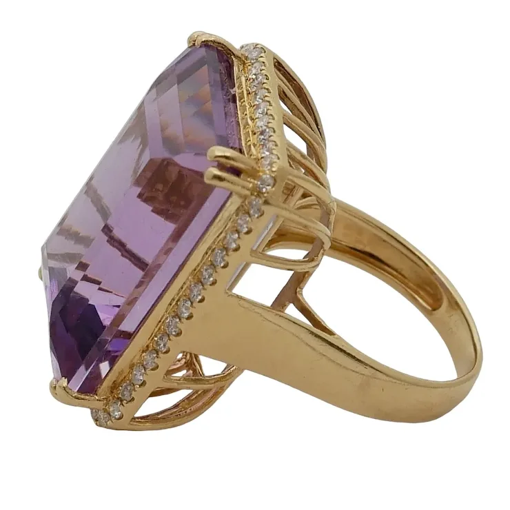 Gold ring with a large purple gemstone on a white background