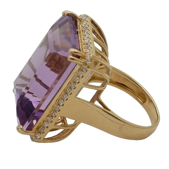 Gold ring with a large purple gemstone on a white background