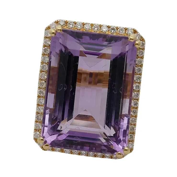 Purple gemstone ring with gold and diamond accents on a white background