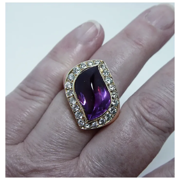 Ring with a purple gemstone and diamond accents on a finger against a white background