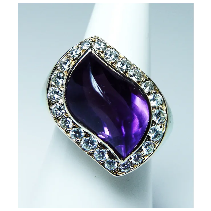 Ring with a purple teardrop-shaped gemstone and diamond-studded band on a white background