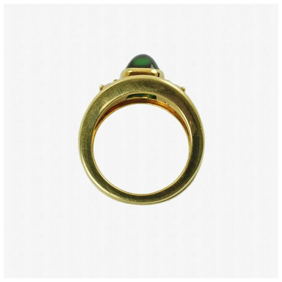 Gold ring with a green gemstone on a white background