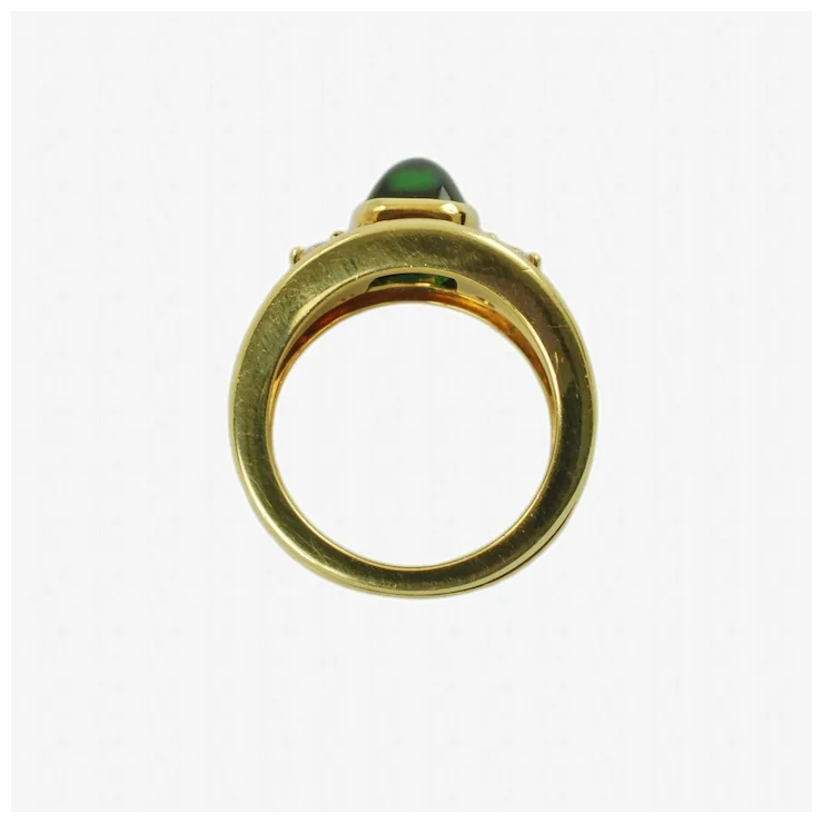 Gold ring with a green gemstone on a white background